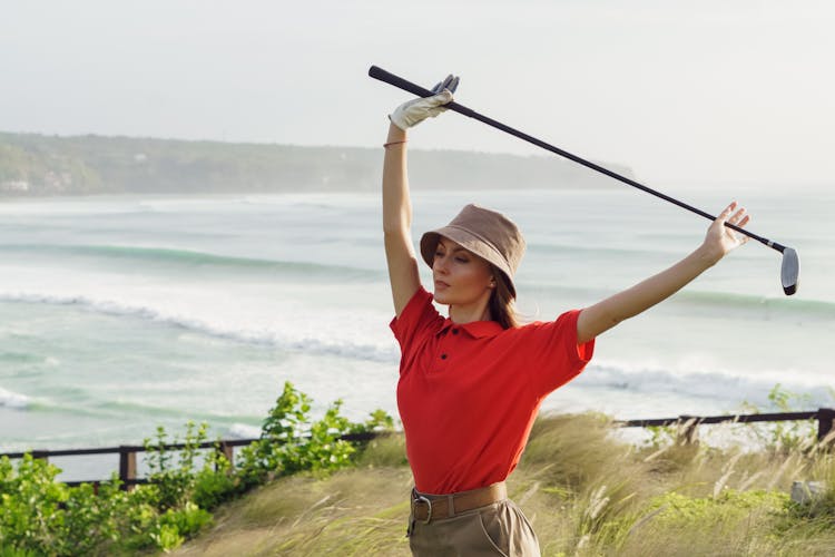 Woman In Red Polo Shirt Holding A Golf Club