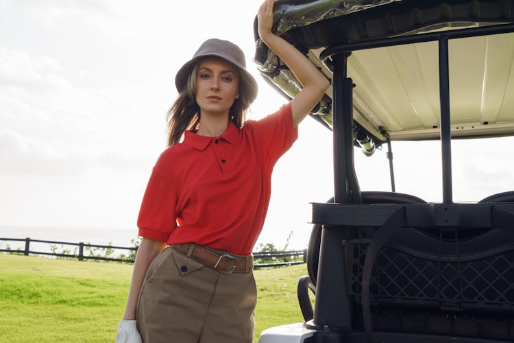 Beautiful Woman Standing Beside A Golf Cart