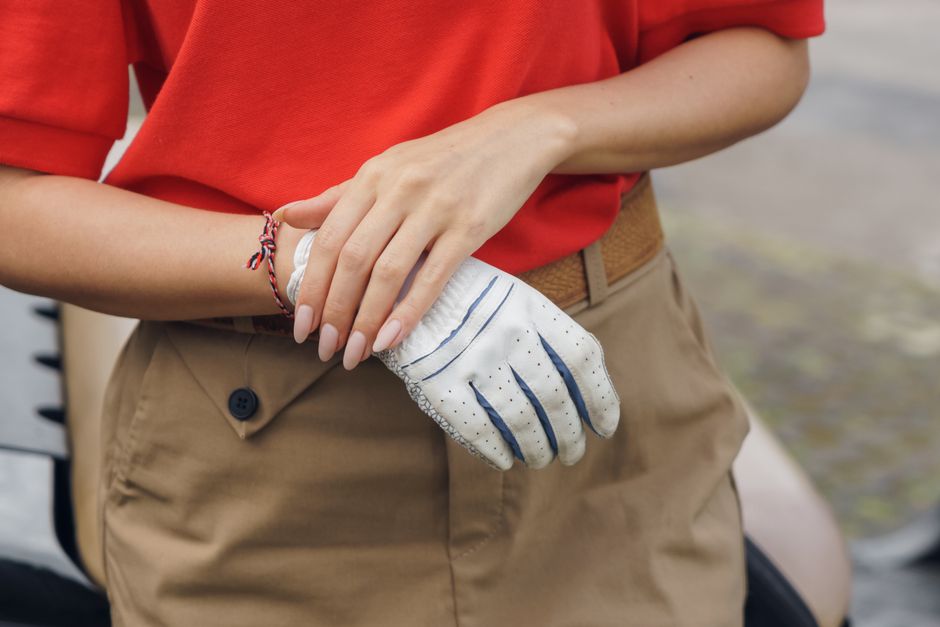 Close-up view of an individual wearing a golf glove and a casual outfit.