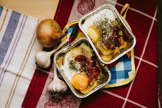 Delicious baked egg dish with vegetables in aluminum trays on a colorful tablecloth.