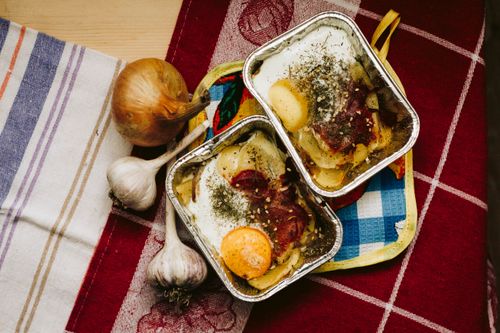 Free Delicious baked egg dish with vegetables in aluminum trays on a colorful tablecloth. Stock Photo