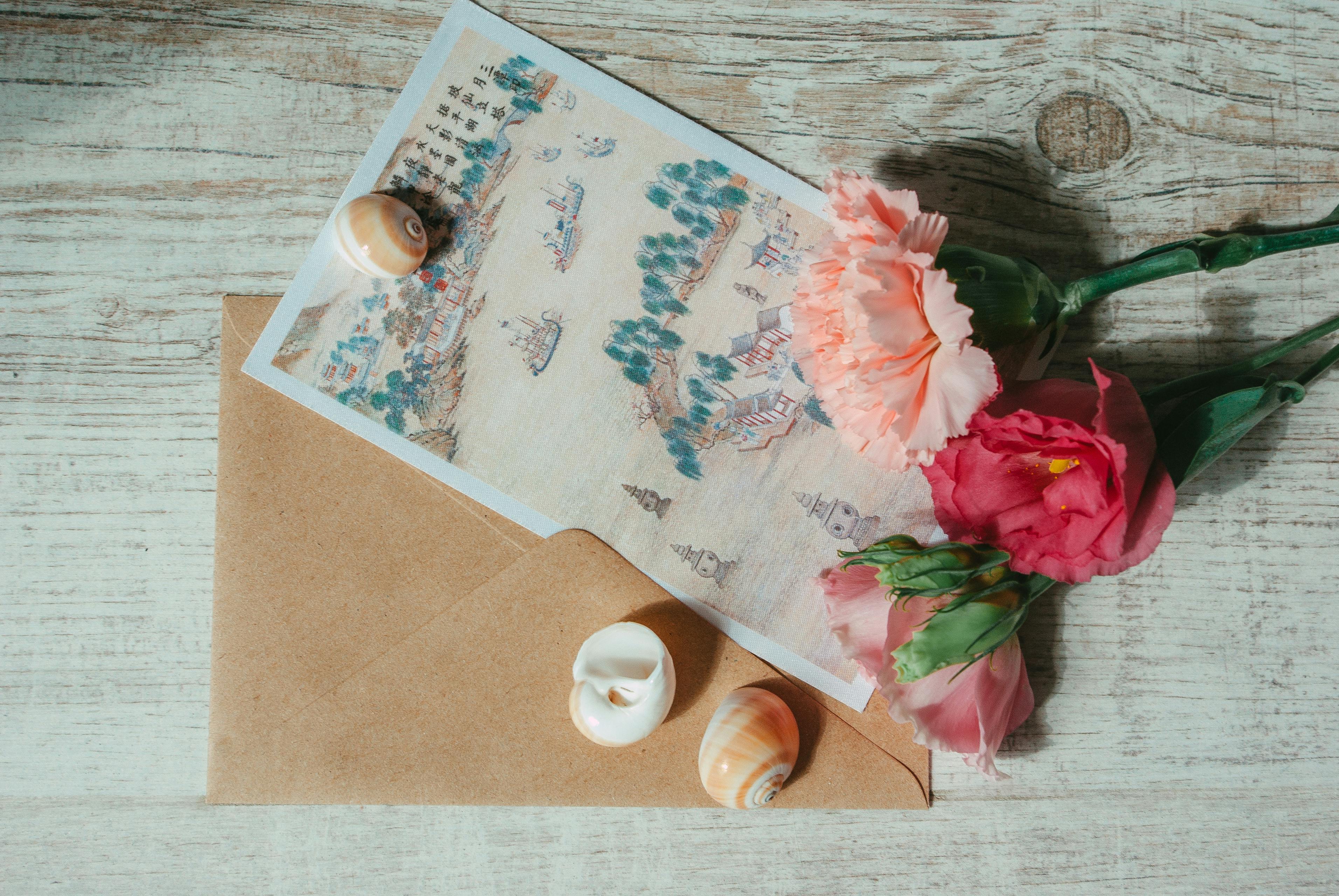A beautiful vintage postcard with flowers and seashells on a wooden surface, offering a nostalgic and artistic feel.