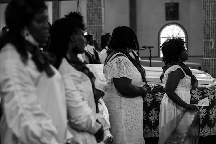 Grayscale Photo Of Women At A Funeral