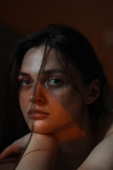 A captivating portrait of a woman in soft, warm lighting, creating a moody and introspective atmosphere.