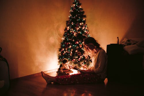 Photo De Femme Assise Près De L'arbre De Noël