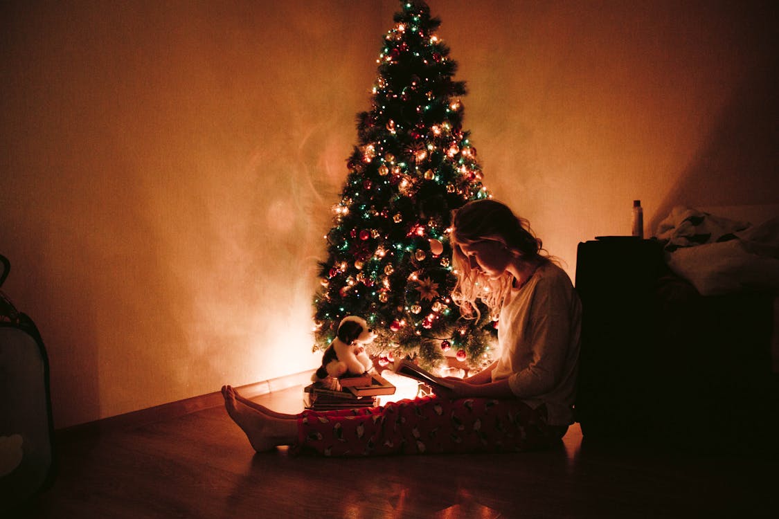 Foto De Mulher Sentada Perto Da árvore De Natal