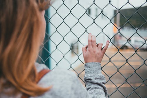 Free A Woman holding a Fence Stock Photo