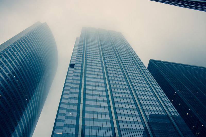 Modern skyscrapers reaching into foggy skies