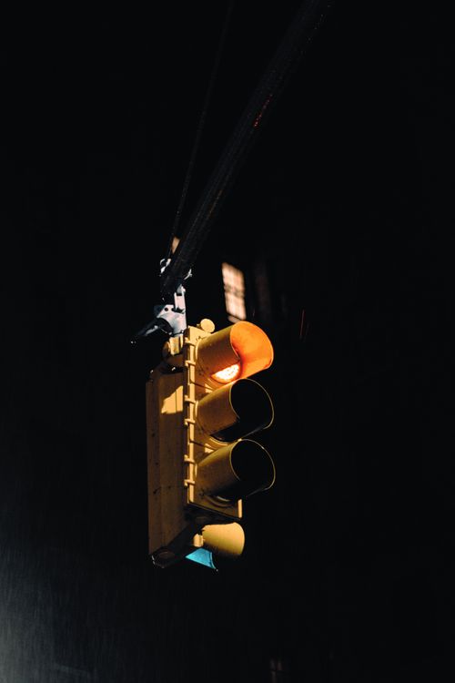 Free A glowing traffic light shines in darkness, capturing an urban night mood. Stock Photo