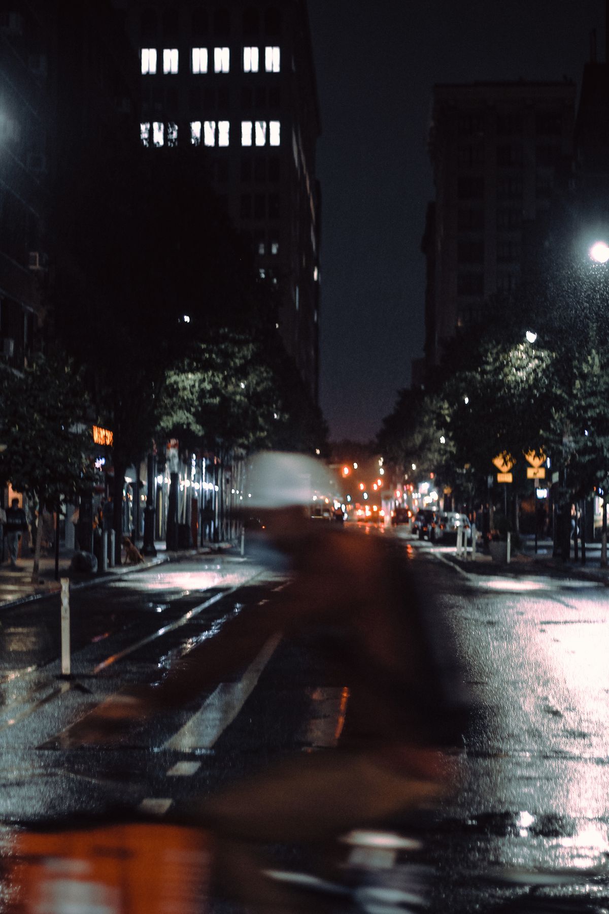 Cyclist riding on an illuminated city street at night