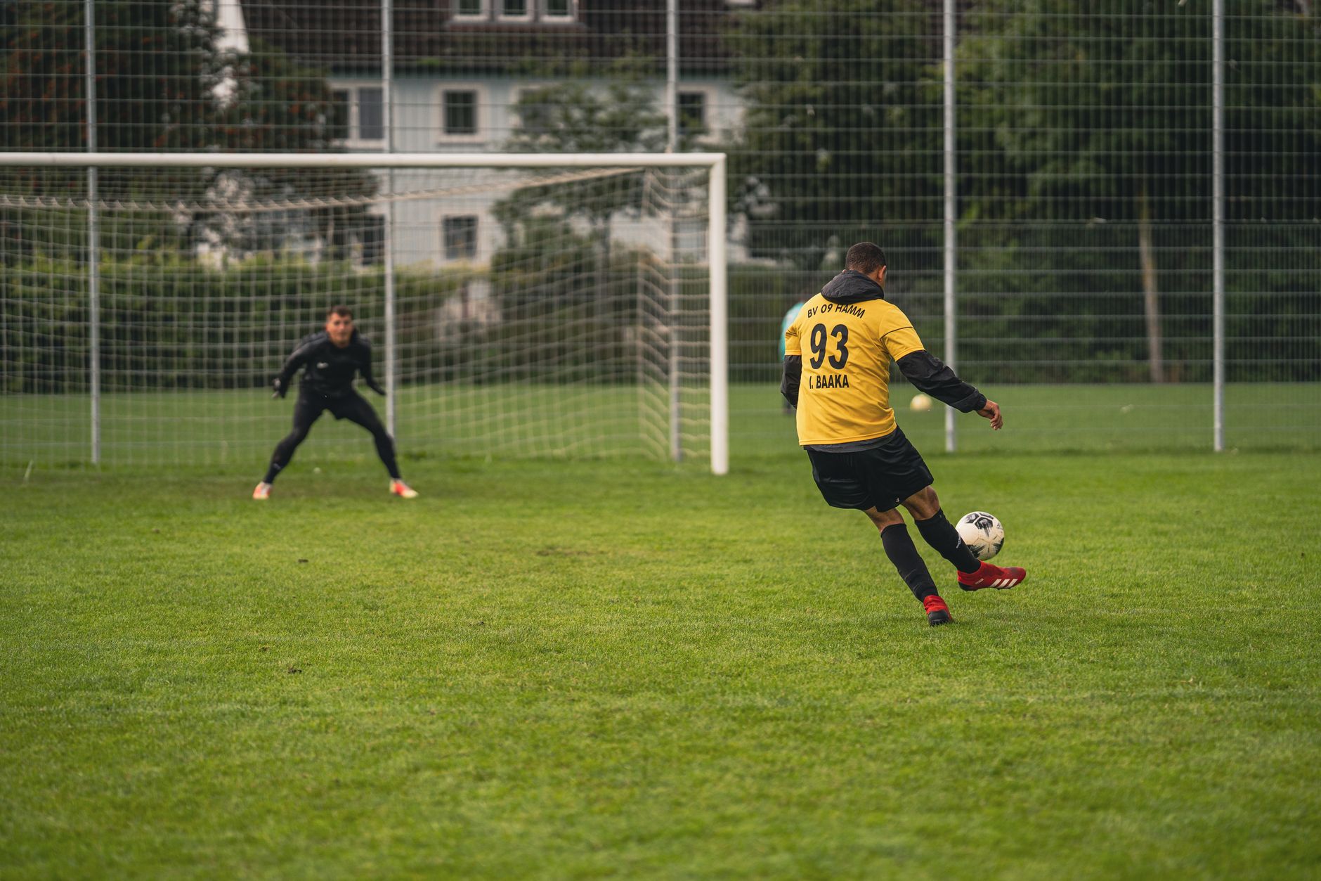 Soccer player in action on a green field, aiming for the goal.