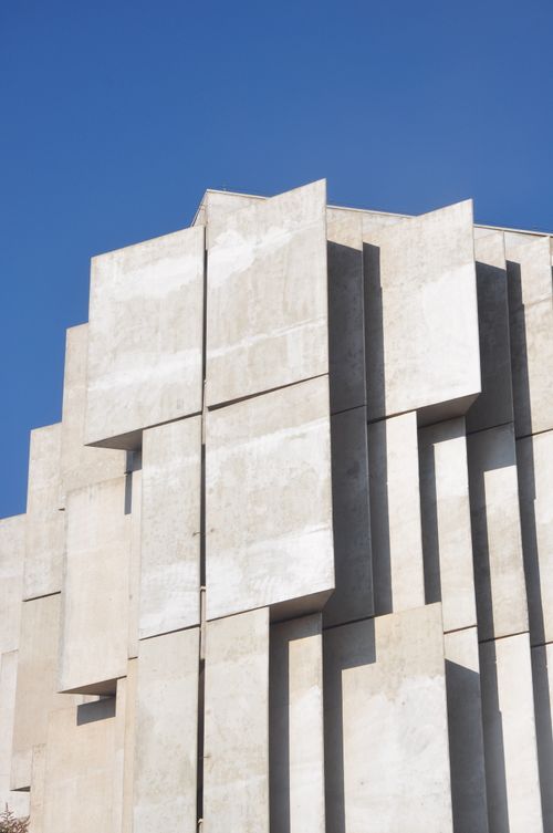 Free Abstract view of a modern concrete building showcasing geometric patterns against a clear blue sky. Stock Photo