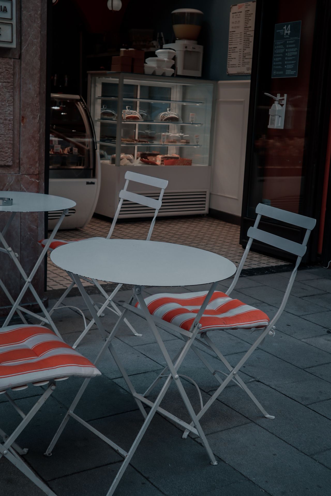 themed-outdoor-pillows White chairs with red striped cushions on an outdoor patio