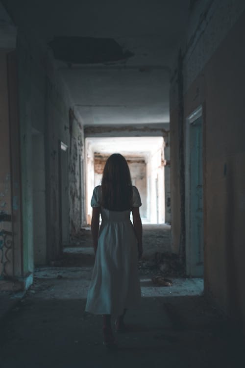 Woman in White Dress Walking on Hallway