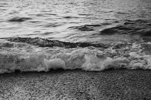 Grayscale Photo of Waves on Shore