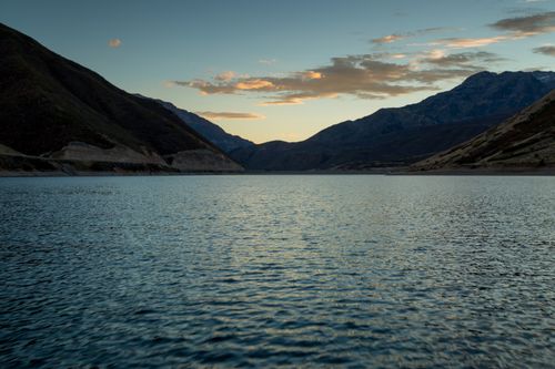 Free Peaceful mountain lake at twilight with calm waters and dramatic sky. Stock Photo