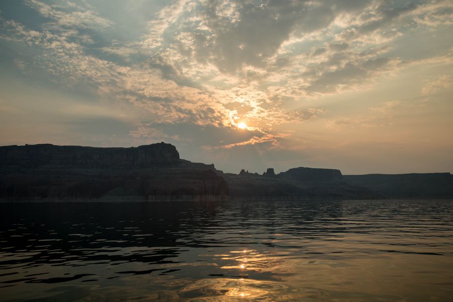 Sunset over a desert lake with cliffs reflected in still water, photo by Aaron Mefford on Pexels