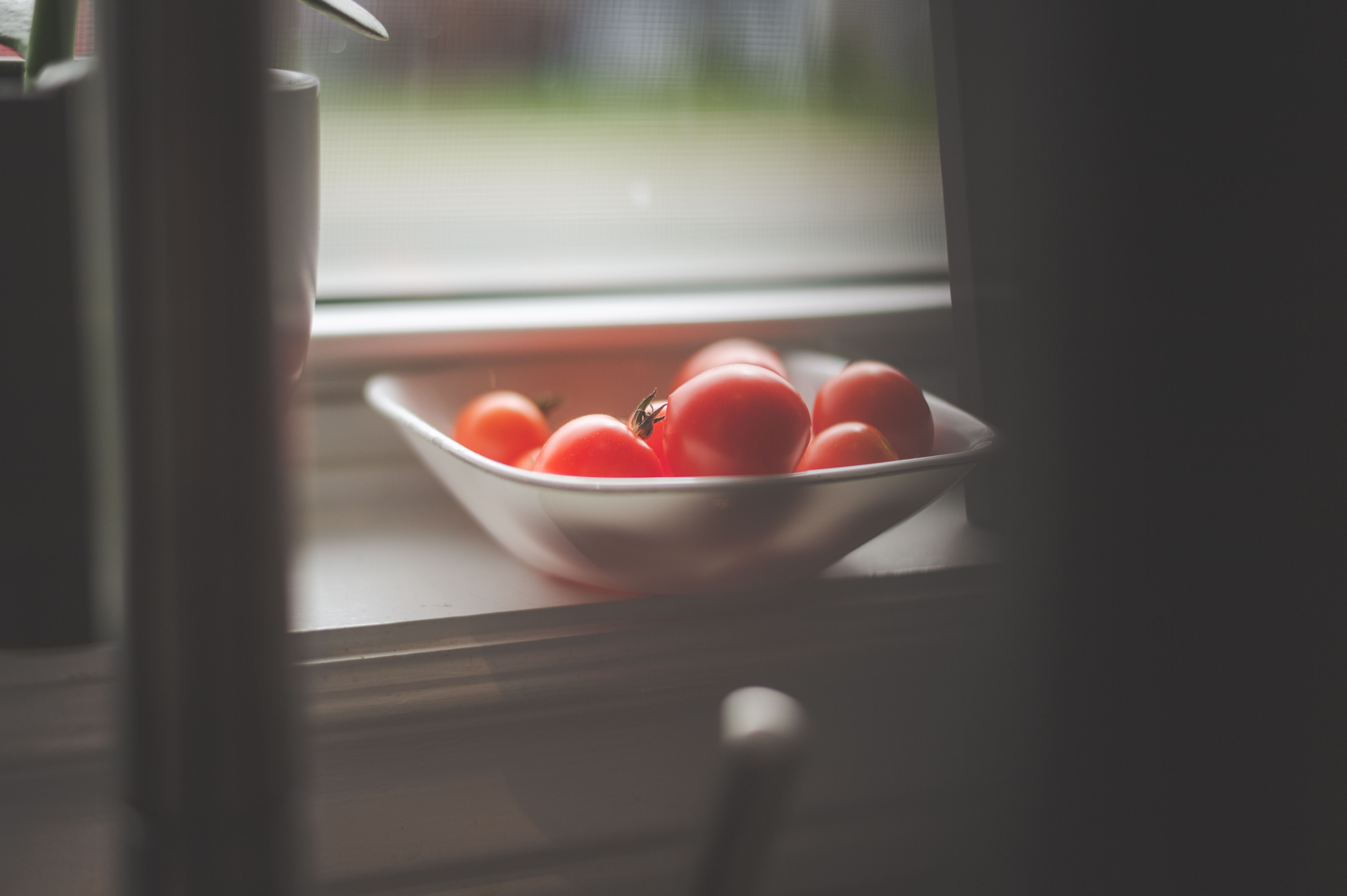 Sunlight streaming through a kitchen window, illuminating a bowl of fresh vegetables