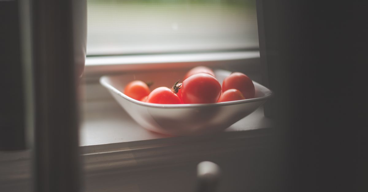Sunlight streaming through a kitchen window, illuminating a bowl of fresh vegetables