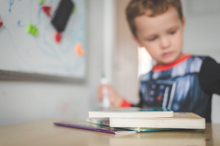 Little Boy Sitting With Books 