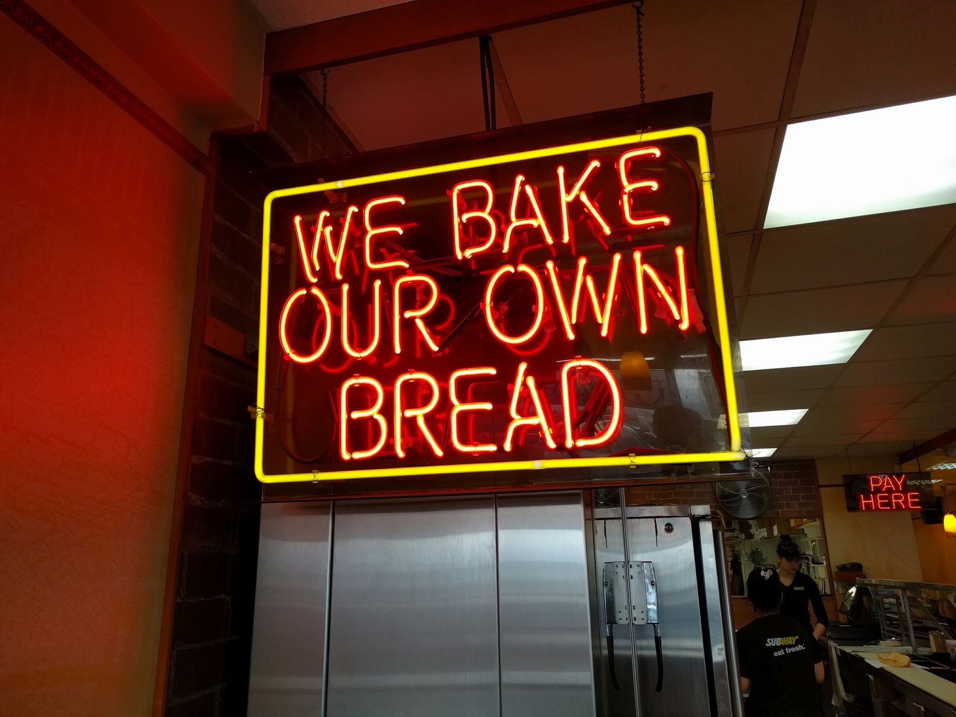 Bright neon sign in a bakery showcasing fresh bread with a modern vibe.
