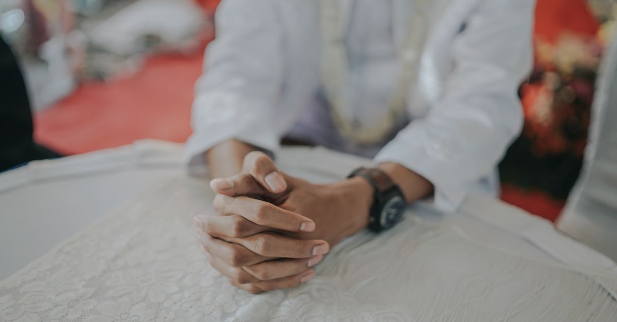 hands folded in prayer with soft morning light
