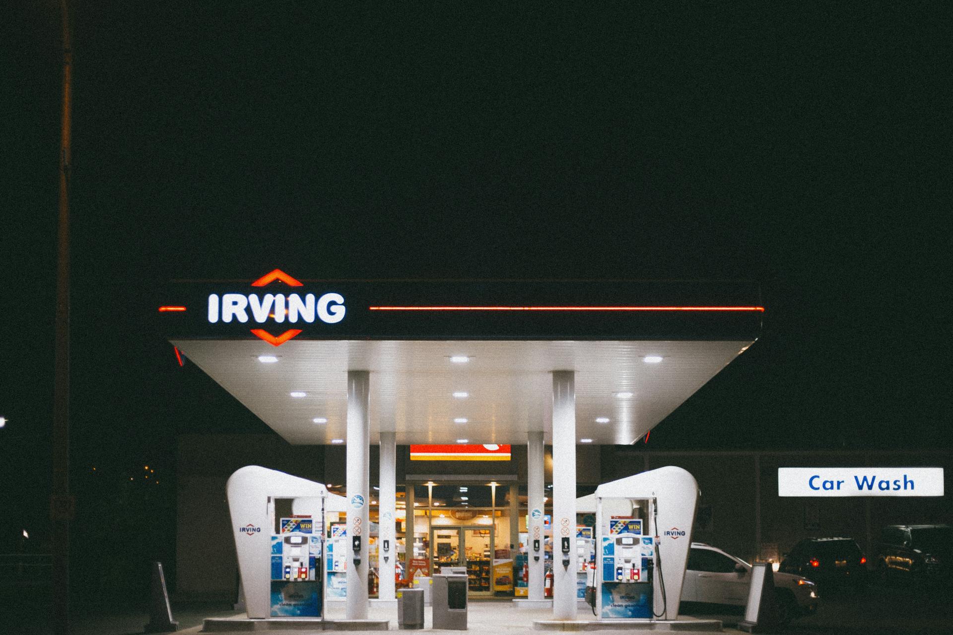 A dimly lit Irving gas station at night with an adjacent car wash sign visible.