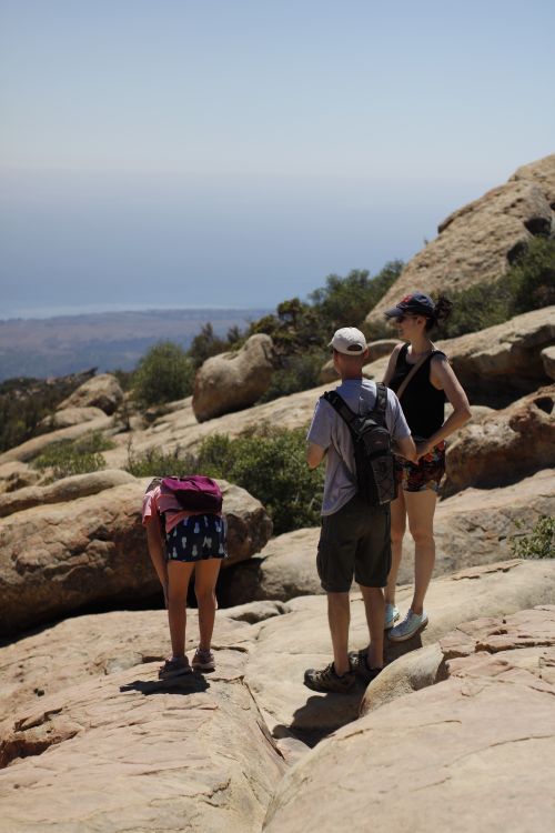 Free Group of backpackers enjoying a scenic hike with ocean in the distance. Stock Photo