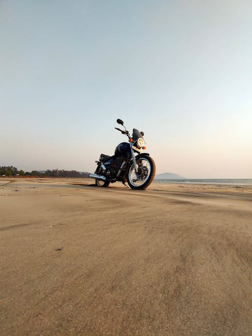 Black Motorcycle Parked on Beach Sand