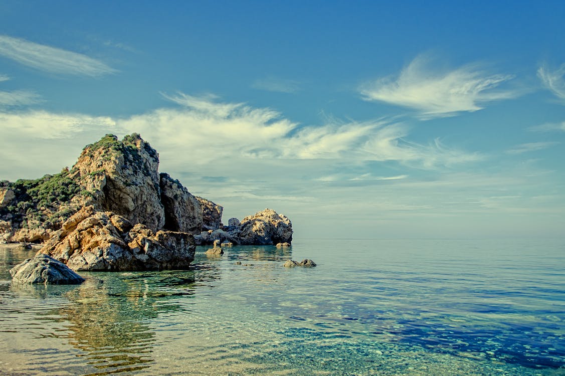 免费 白天平静水体上的悬崖和岩层 素材图片