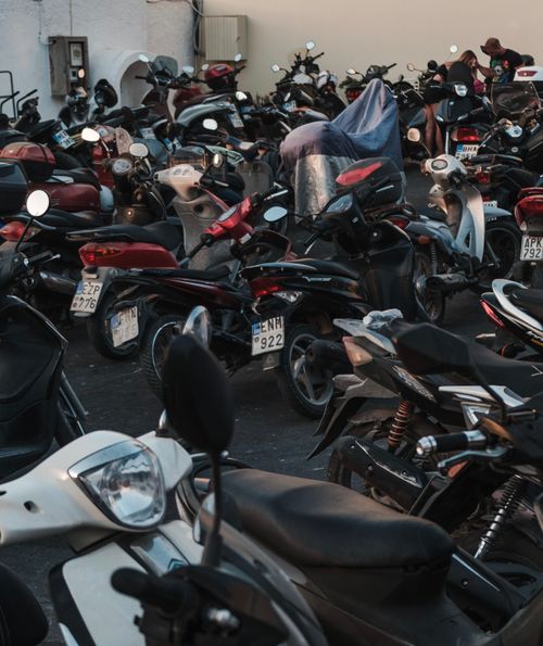 Free A packed parking area filled with various parked motorcycles during the evening. Stock Photo