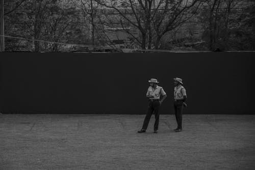 Grayscale Photo of Men Standing on the Field