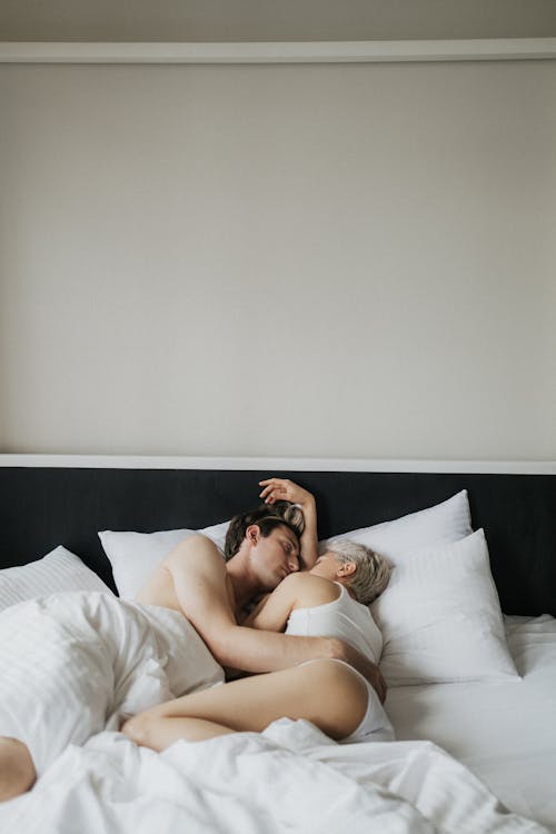 Free A Couple Lying on the Bed Stock Photo