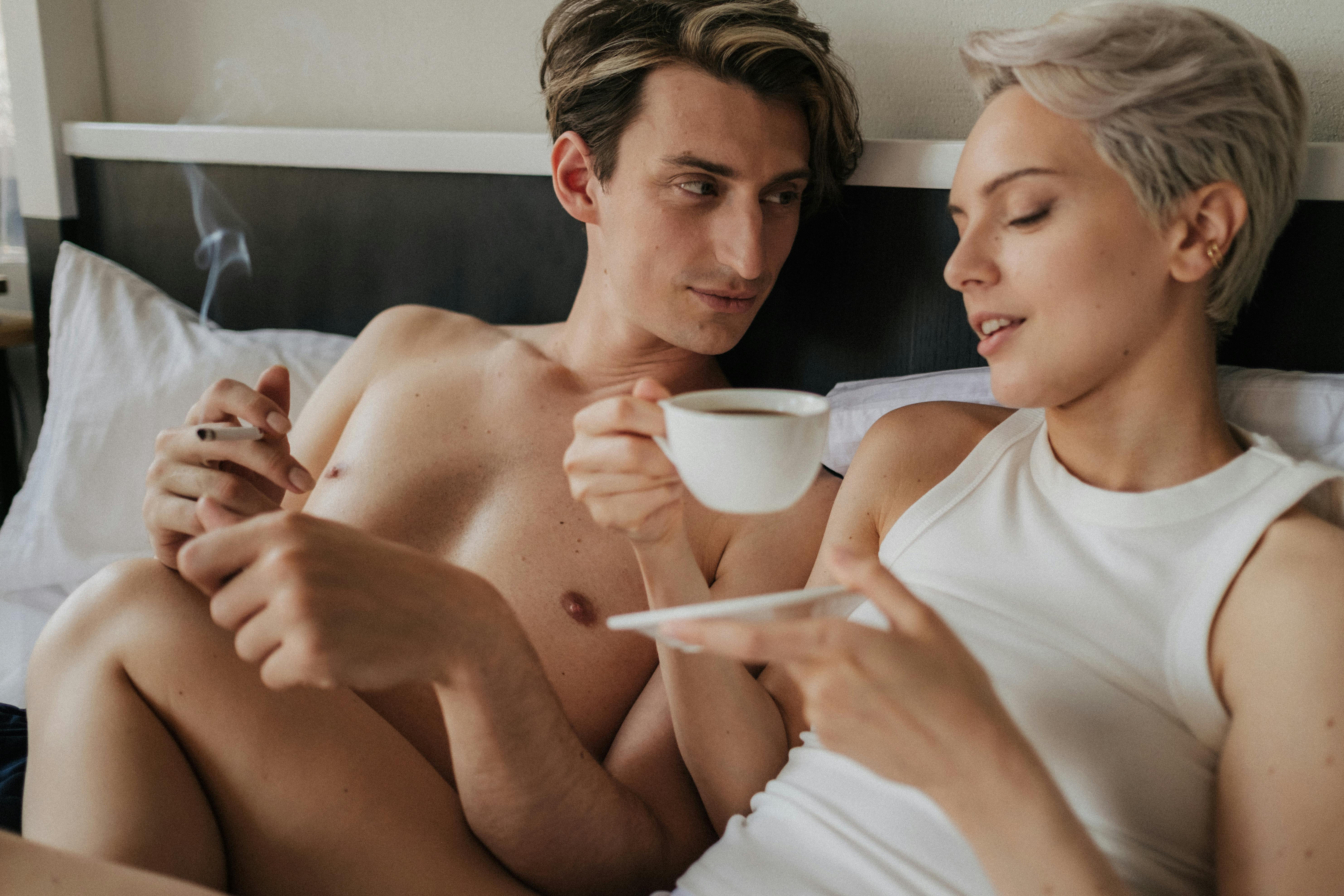 A couple enjoying a relaxed morning with coffee in bed, embracing intimacy and togetherness.