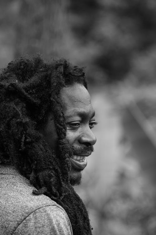 Monochrome Photo of a Man with Dreadlocks Smiling