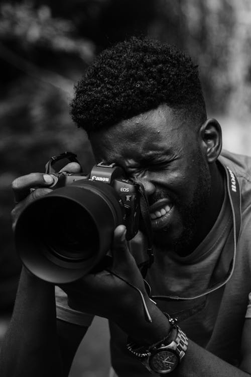 Grayscale Photo of a Man Holding a Dslr Camera