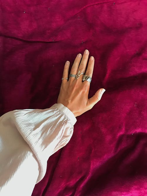 Person Wearing Silver Ring and White Long Sleeve Shirt