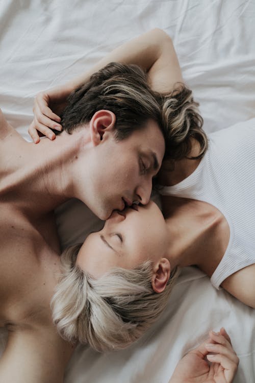 Free A Romantic Couple Kissing on the Bed Stock Photo