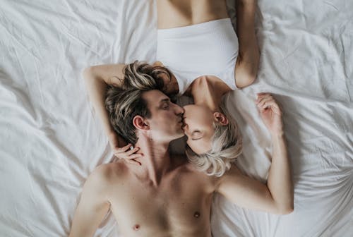 Free Woman and Man Kissing on Bed Stock Photo