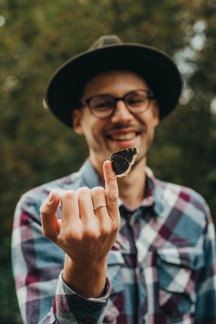 Smiling Man Holding A Butterfly On His Finger 