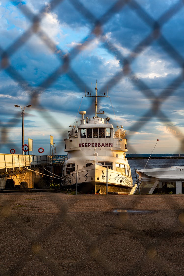 Ship In Harbor Behind Net Fence