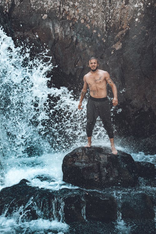 Shirtless Man Standing on a Rock