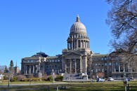 爱达荷州议会大厦矗立在清澈的蓝天下，雄伟壮观，四周环绕着花园