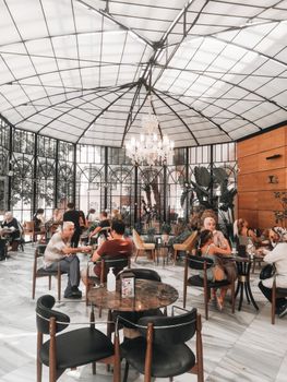 A bustling cafe with elegant design and diverse people enjoying meals.