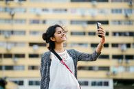 Smiling Woman Holding Black Smartphone