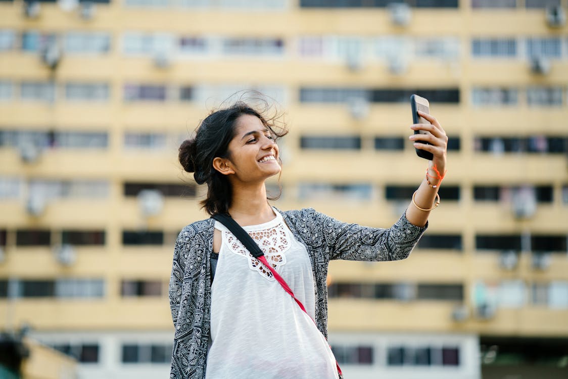 Smiling Woman Holding Black Smartphone