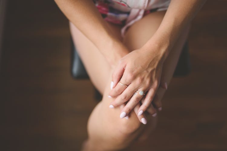 Close-up Of Woman Sitting With Legs And Hands Crossed