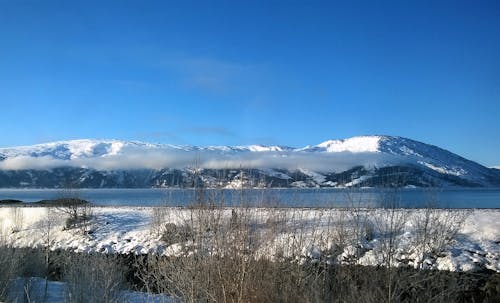 Foto Pemandangan Badan Air Di Pegunungan Bersalut Salju