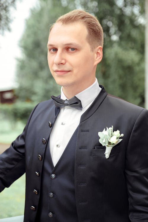 Man in Black Suit Jacket and White Boutonniere on Pocket