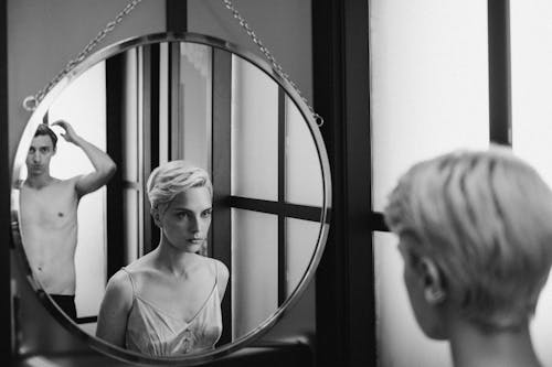 Free Woman in White Top Looking at the Mirror Stock Photo